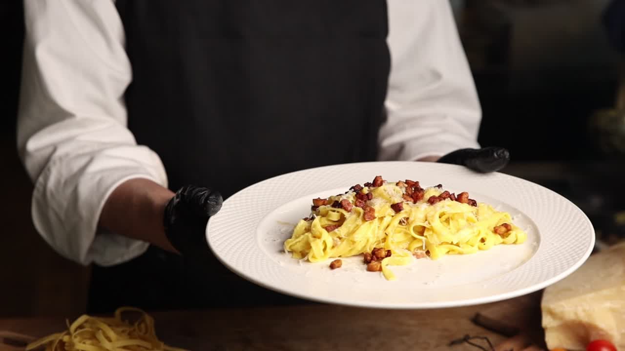 Chef che Presenta un Piatto di Deliziosa Pasta alla Carbonara
