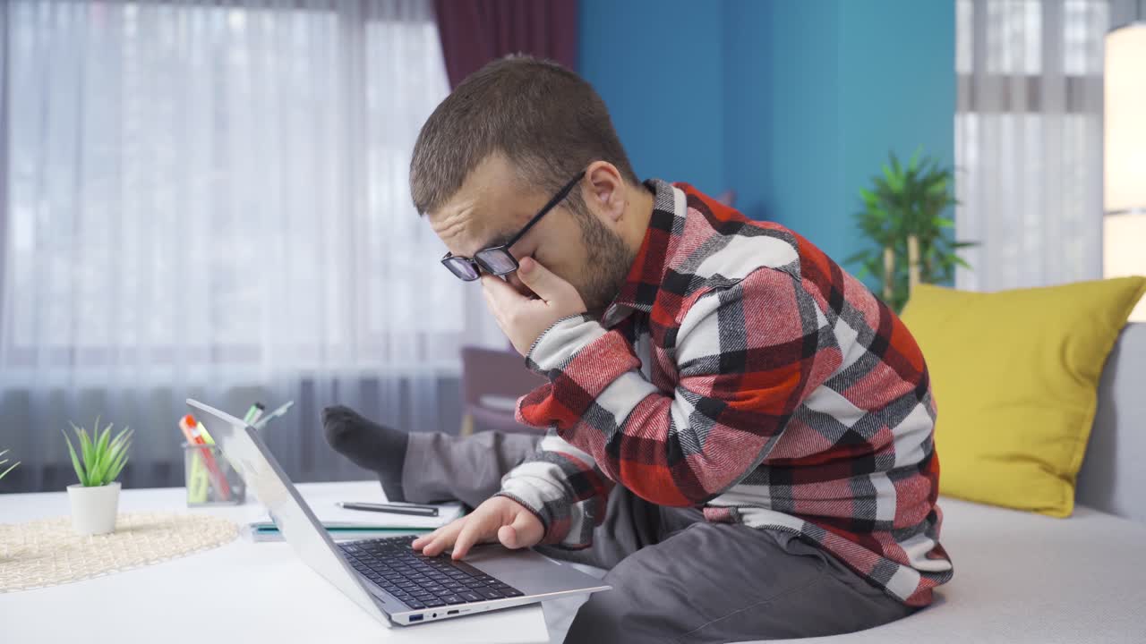 Dwarf young man working on laptop at home tired and sleepy.