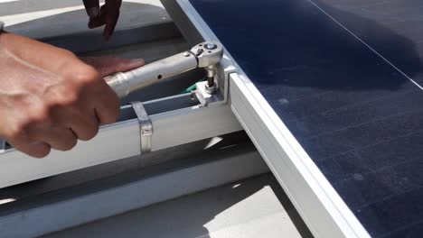 asian man tie the screw of solar panel unit, close up