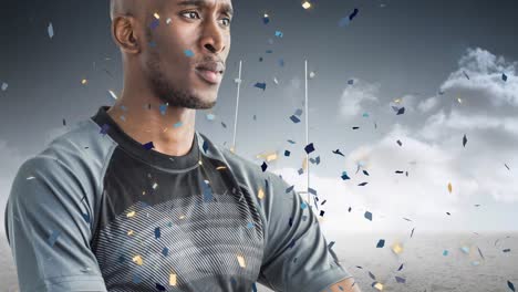 animation of confetti over african american male rugby player with ball at stadium