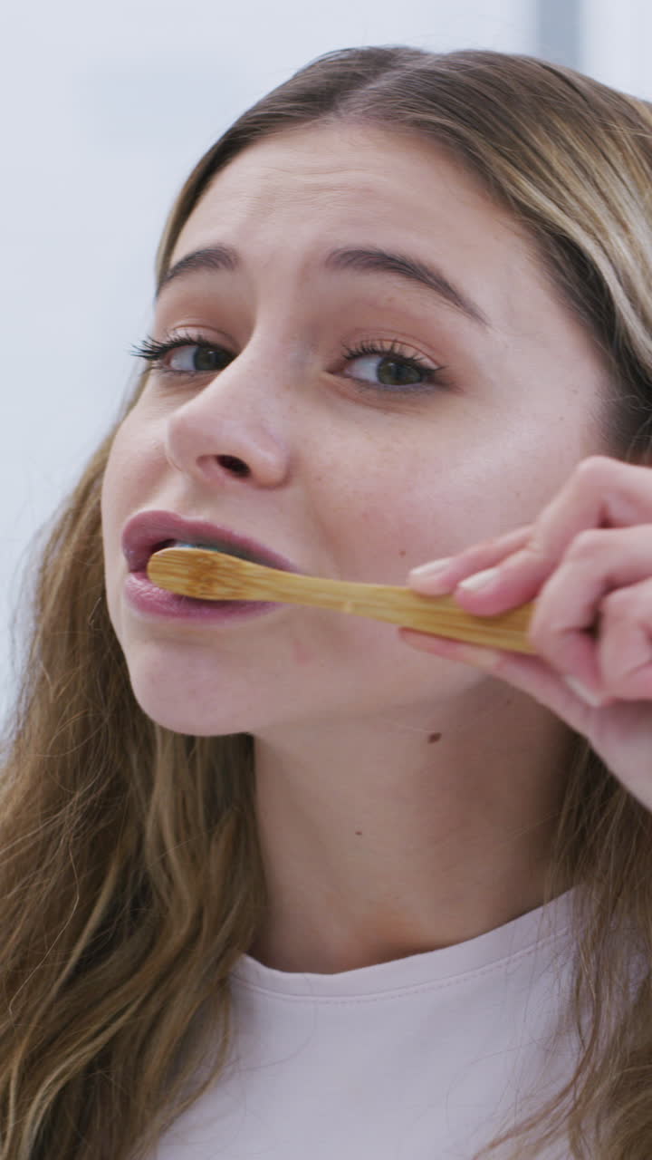 Young Woman Brushing Her Teeth with a Bamboo Toothbrush