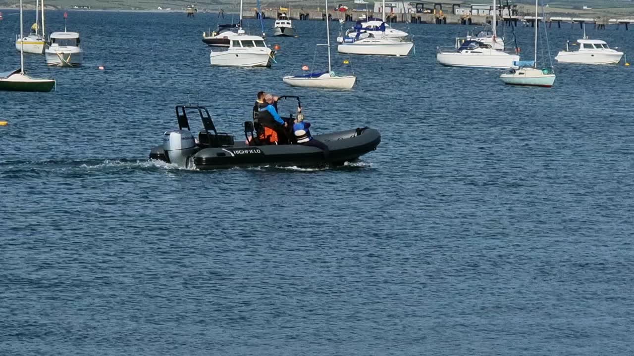 Family voyage on inflatable power boat in Welsh yachting marina leisure activity