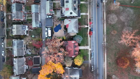 Tracking-shot-of-car-driving-through-urban-city-town-in-autumn,-winter