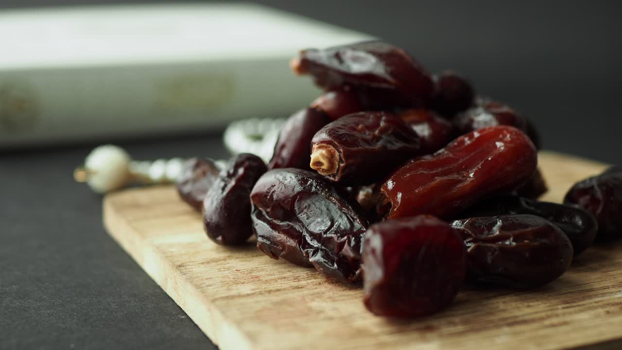 Dried Dates on Wooden Board with Prayer Beads and Quran