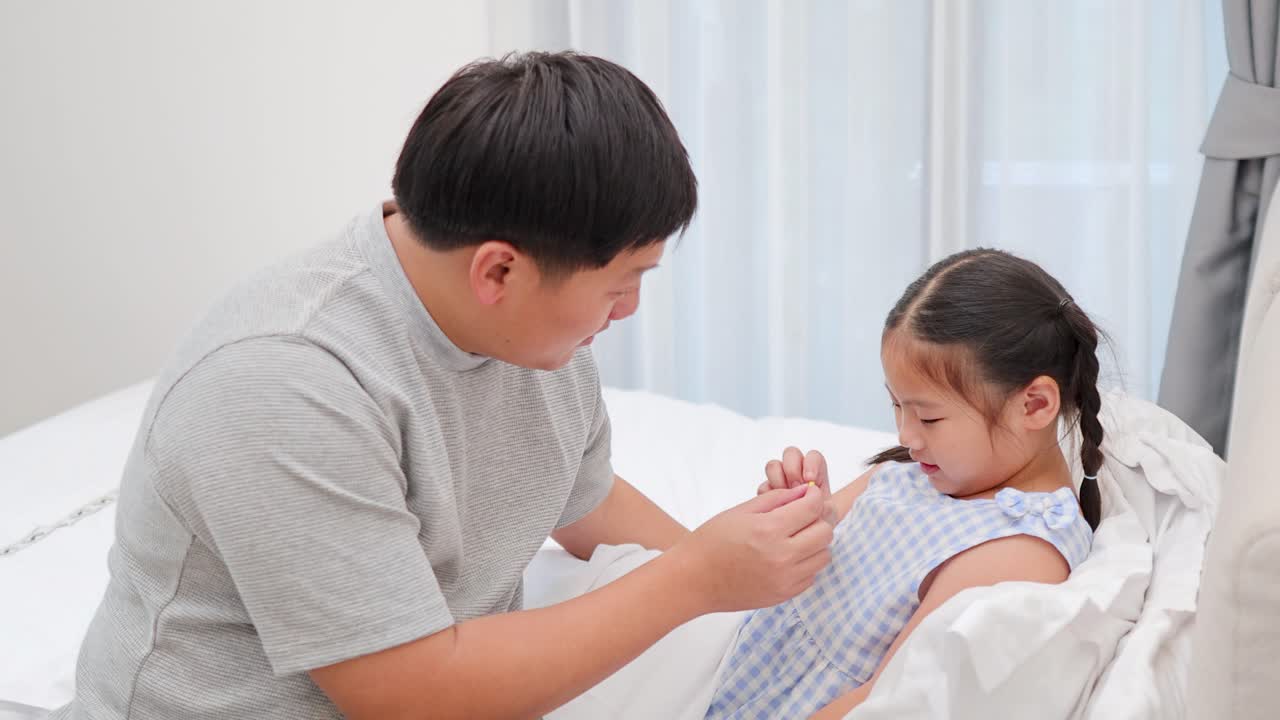 침대에서 딸을 돌보는 아버지