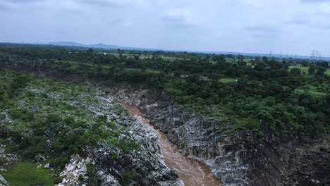 Powerful-Flow-Of-Water-From-The-River-Through-Rugged-Cliffs