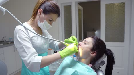 mujer en el higienista dental recibiendo limpieza y blanqueamiento dental profesional. filmado en 4k