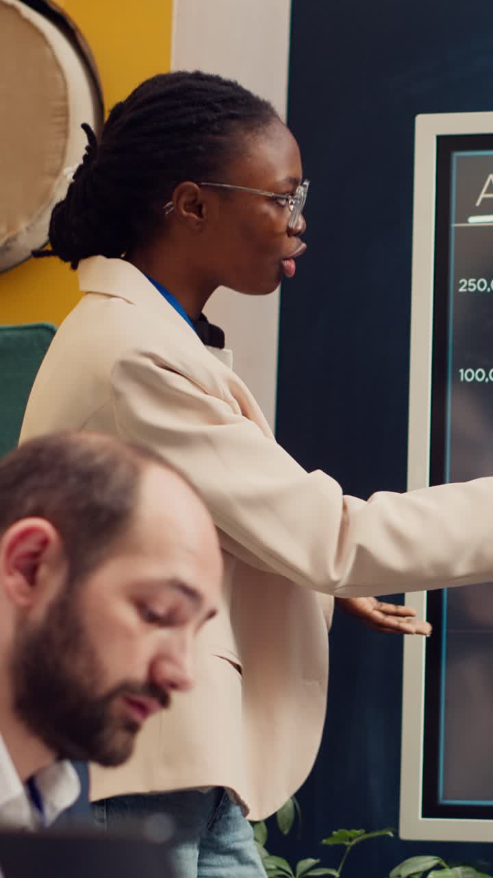 African American Businesswoman Presenting Data on Digital Board in Office Meeting