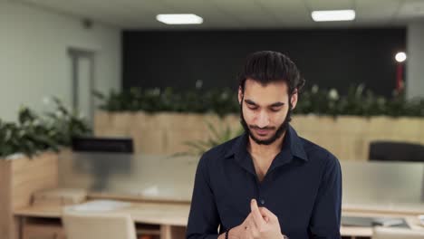 A-young-bearded-man-of-Arab-appearance-looks-at-the-camera-and-smiles