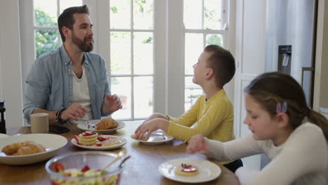 Un-Hombre-Y-Sus-Dos-Hijos-Desayunando-En-Casa