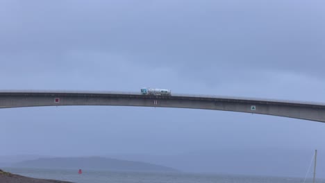 Toma-Panorámica-Lenta-De-Un-Gran-Camión-Conduciendo-Sobre-El-Puente-De-La-Isla-De-Skye.