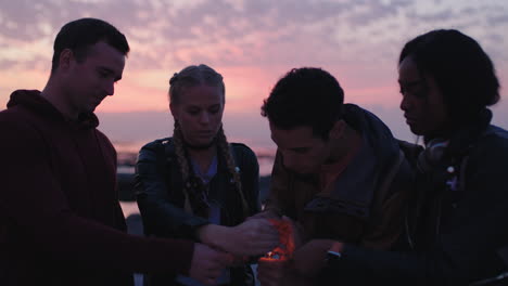 Un-Grupo-De-Jóvenes-Amigos-Encendiendo-Bengalas-En-La-Fiesta-De-Nochevieja-En-La-Playa.