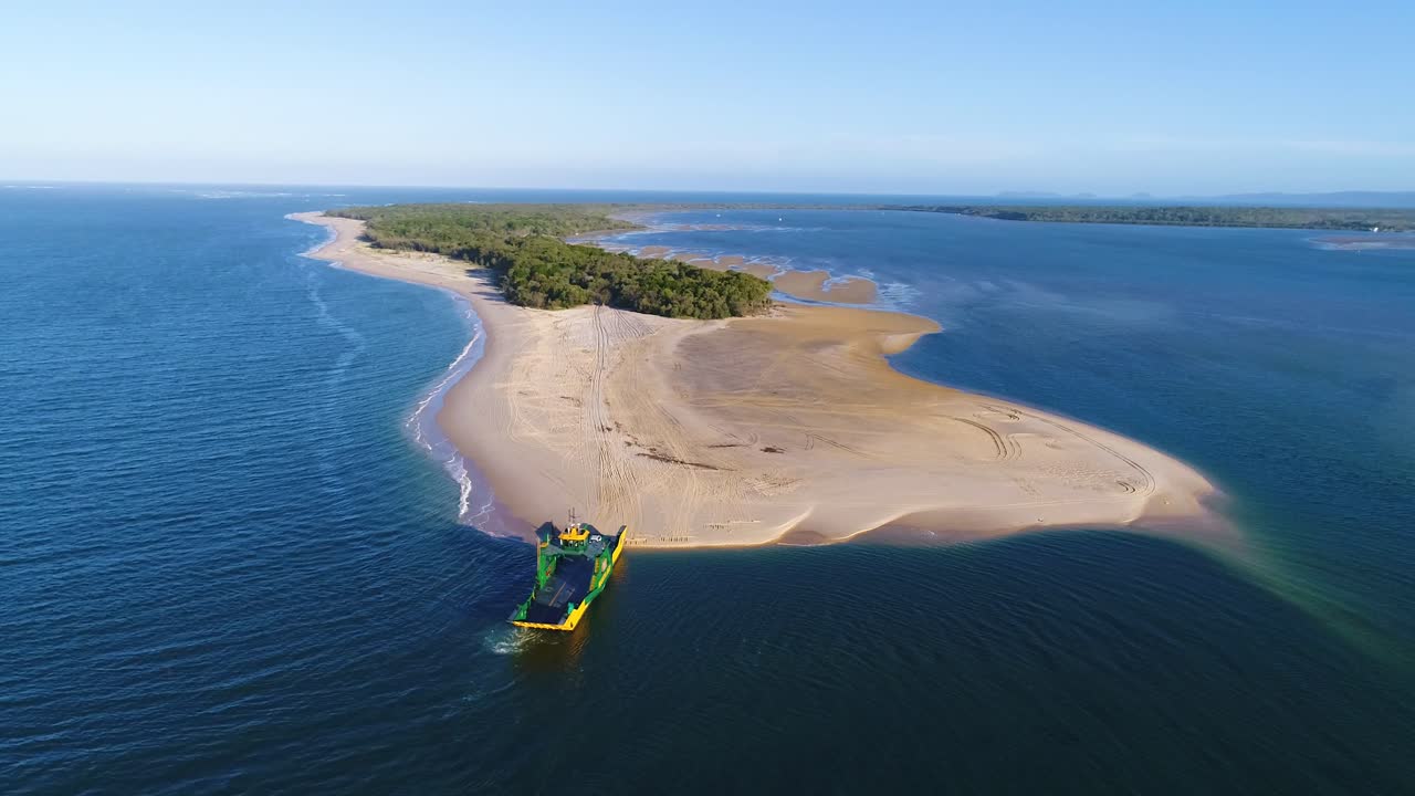 una furgoneta se aleja de un gran buque y llega a rainbow beach en queensland, australia
