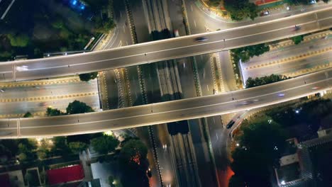 Top-down-rotating-timelapse-of-busy-overpass-intersection-at-night-in-Kuningan-city,-Jakarta---Indonesia