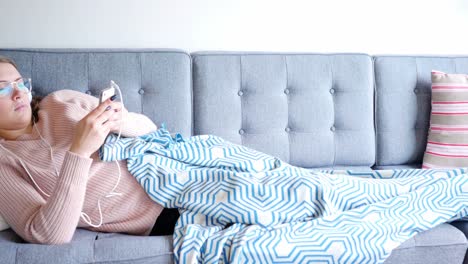 Woman-listening-to-music-with-headphones-from-her-mobile-phone