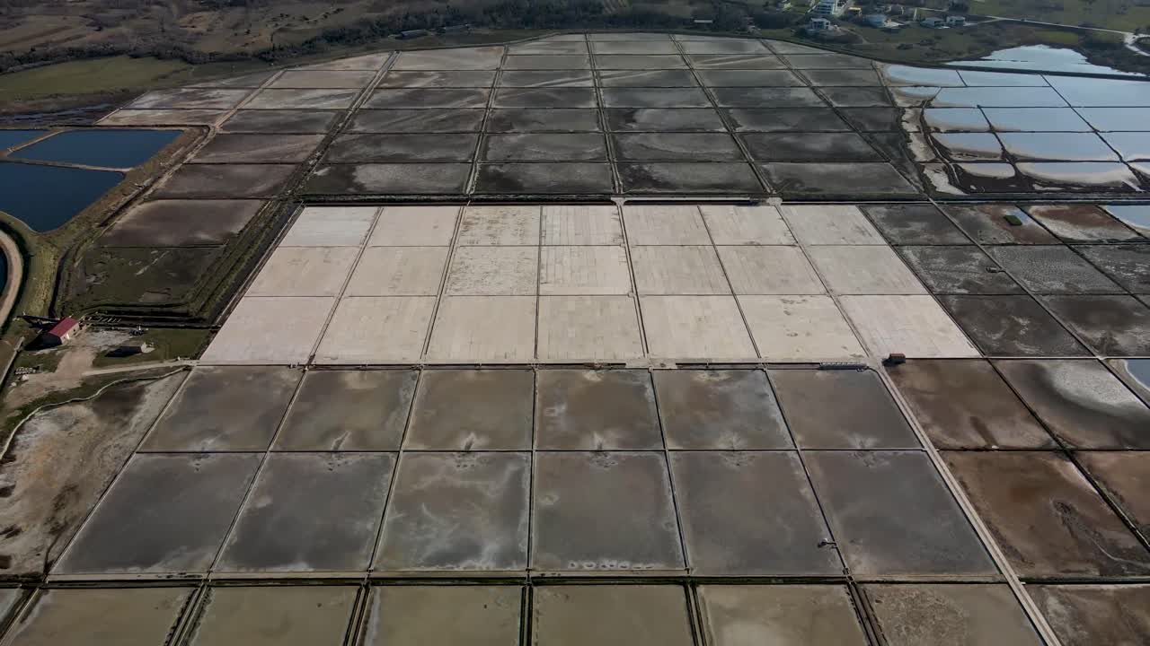 vuelo lento de drones inverso junto a un campo de sal en croacia en la ciudad de nin con carretera y algunos autos durante el día