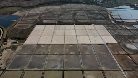 slow reverse drone flight next to a salt field in croatia in nin town with road and a few cars at daytime