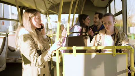 Young-woman-talking-on-the-phone-in-the-bus