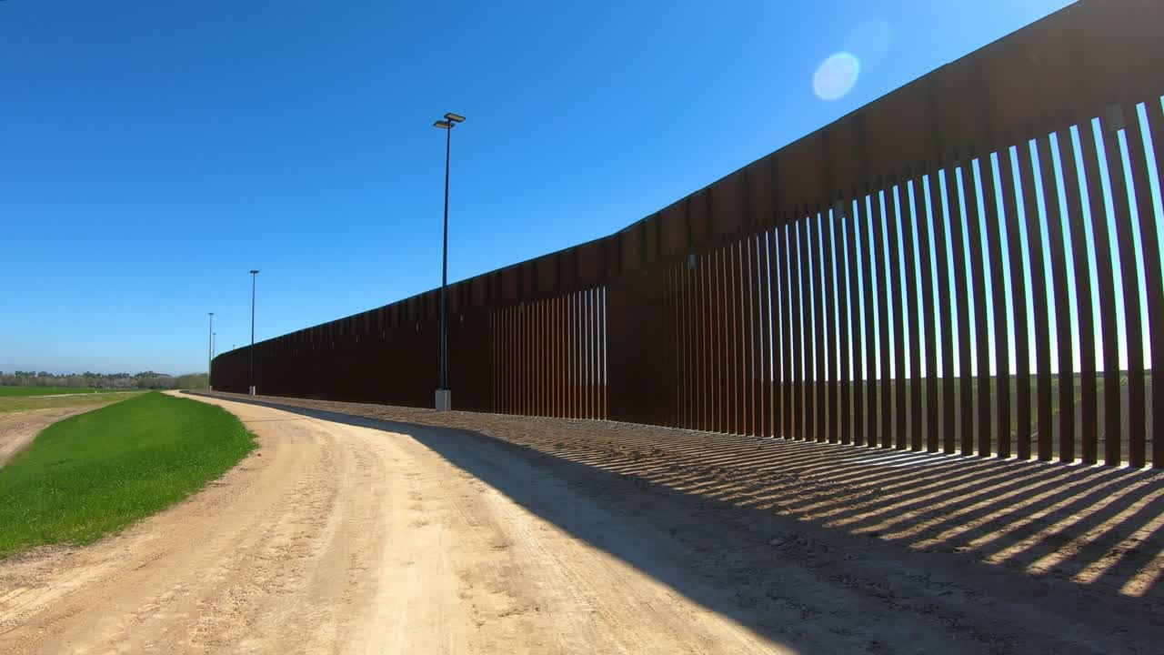 pov conduciendo en la carretera de servicio de grava tejana para el muro fronterizo entre estados unidos y méxico