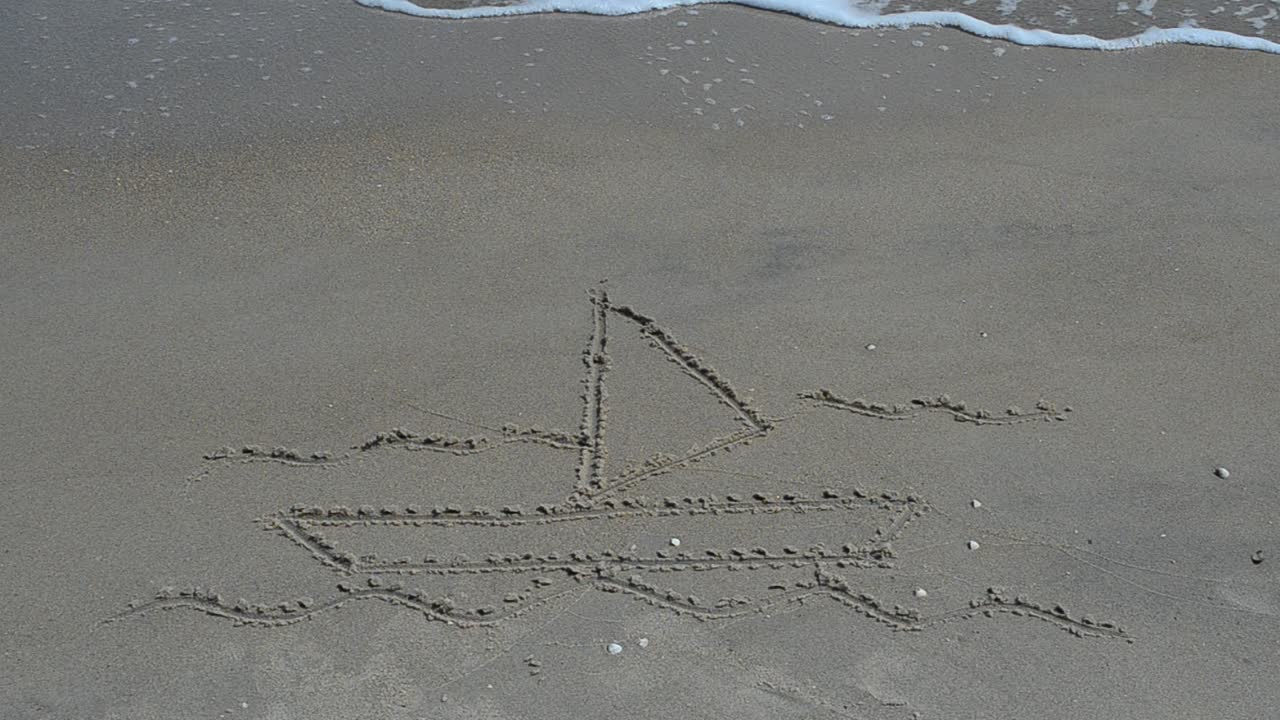 Disegno sulla sabbia: barca, onde e gabbiani in primo piano. Scatto sulla spiaggia.