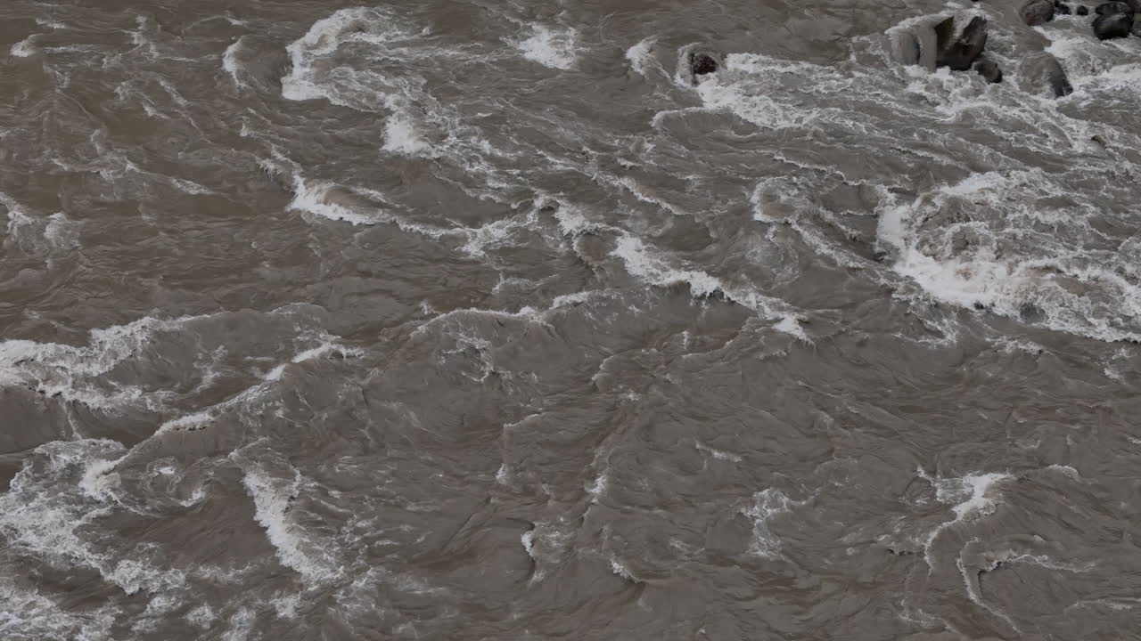 Drone shot of river flooding during monsoon in Nepal, intense water waves and rising levels