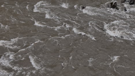 drone shot of river flooding during monsoon in nepal, intense water waves and rising levels