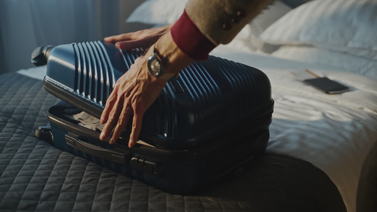 Man With Carefully Folds Clothes Into Compact Suitcase in Cozy Hotel Room (Stock Footage)