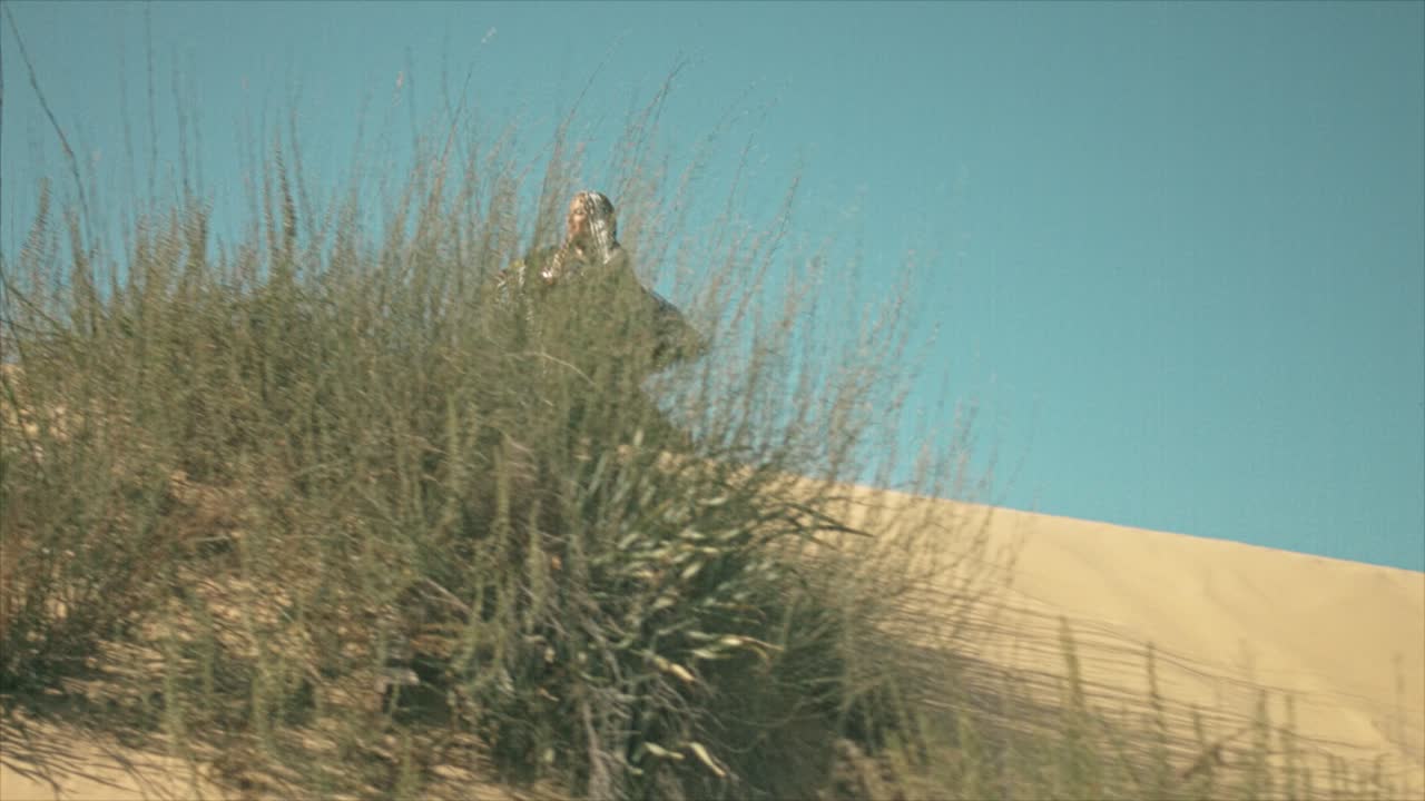 그녀의 드레스를 흔들며 사막 모래 언덕에서 춤을 추는 집시 여자