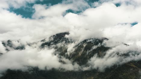 majestuoso volcán tungurahua asomándose a través de la atmósfera nublada dentro de los confines de baños en ecuador-provincia de tungurahua