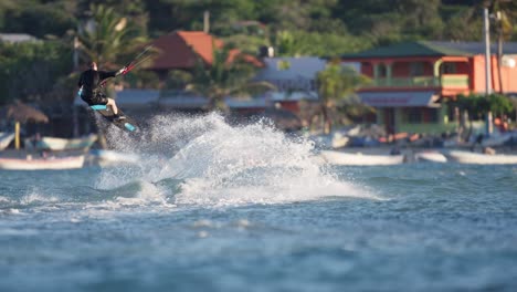 Un-Joven-Hace-Un-Truco-De-Salto-En-Kitesurf-Por-La-Costa-Del-Mar-Caribe,-Slomo