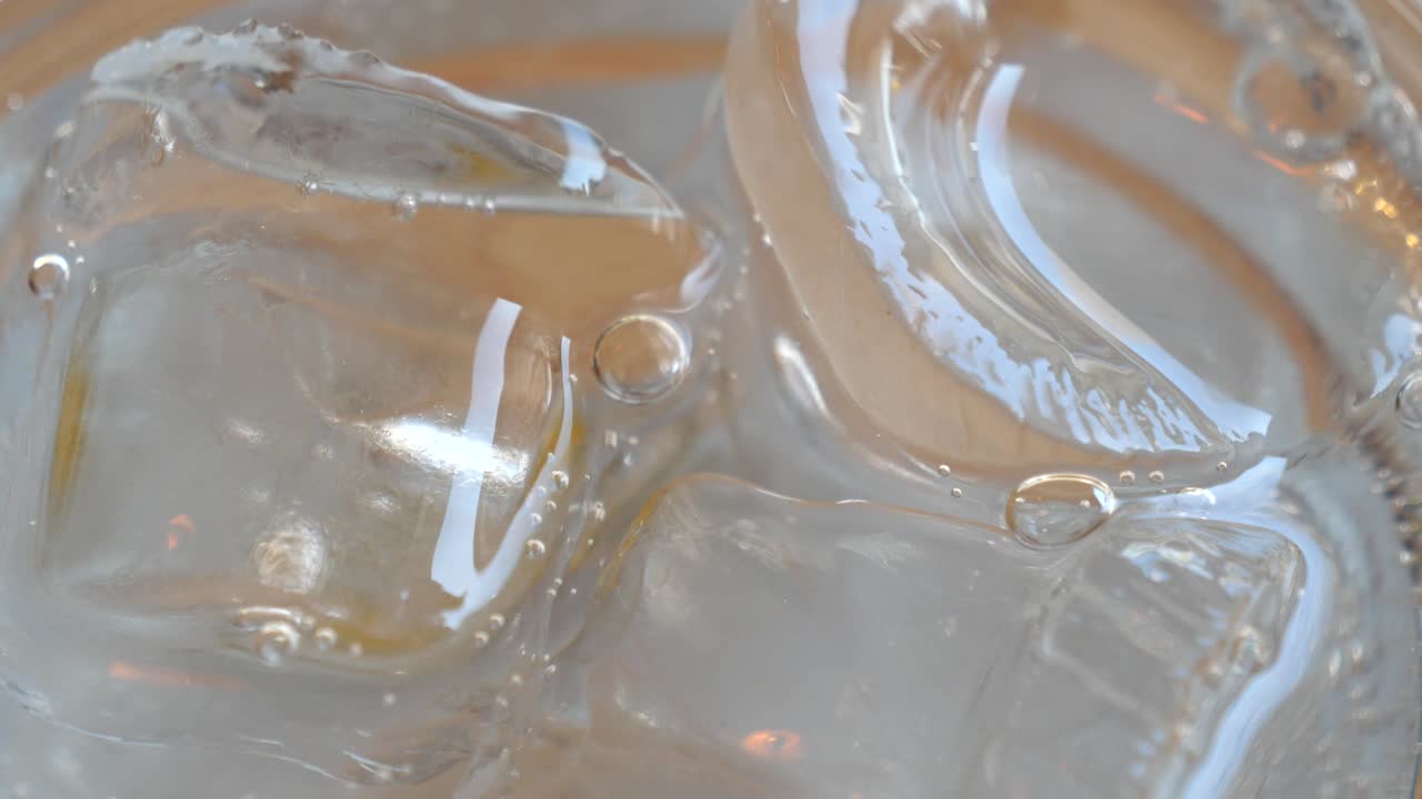 Close-up of water being poured into a glass with ice