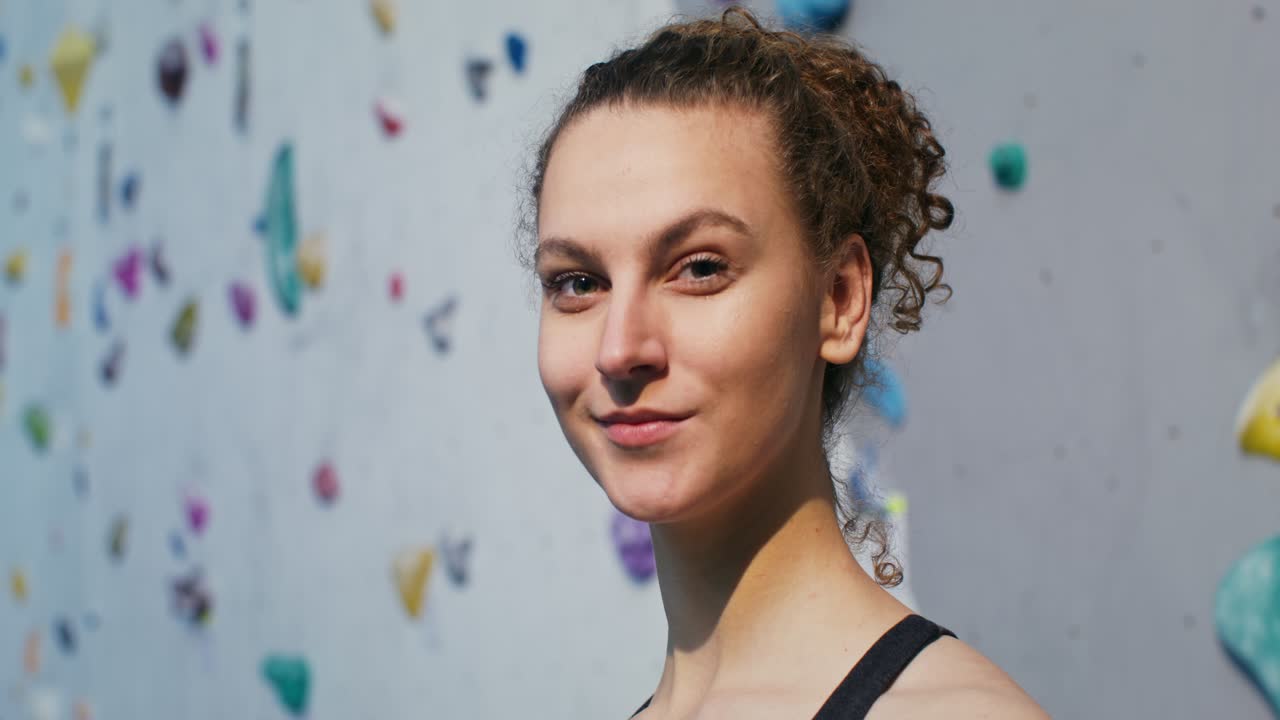 mujer sonriendo en un gimnasio de escalada en roca