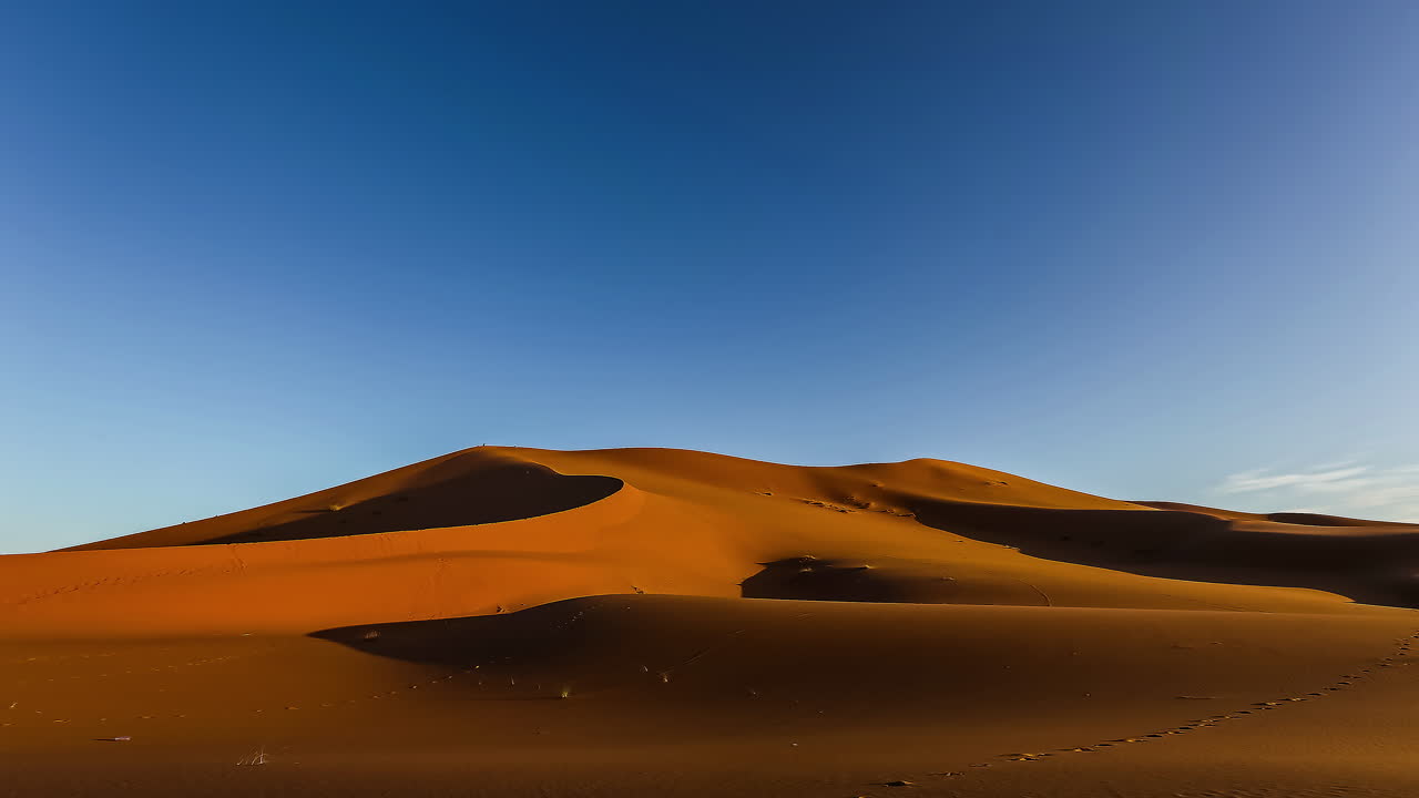 tiro de lapso de tiempo de las dunas del desierto arenoso en áfrica durante el amanecer soleado y el cielo azul