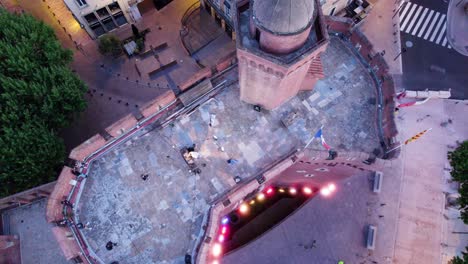 rotating overhead clip of dj performing on rooftop terrace of le castillet fortress in perpignan, france at dusk