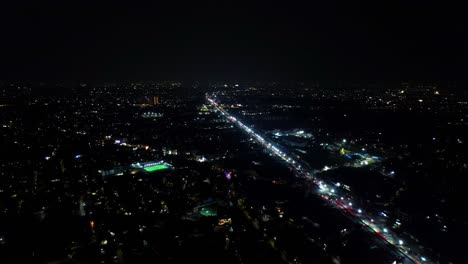 pan drone shot of night view of a city with busy roads. dark landscape.