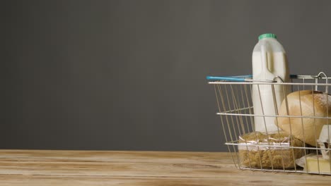 studio shot of basic food items in supermarket wire shopping basket 6