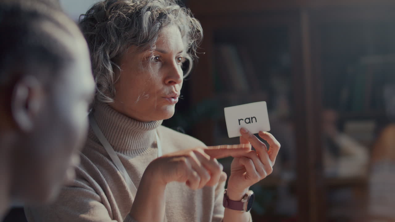 English Teacher Demonstrating Verb Past Tense with Flashcard during Lesson