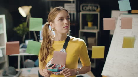 mujer de negocios satisfecha buscando en el tablero de ideas en una oficina hipster.