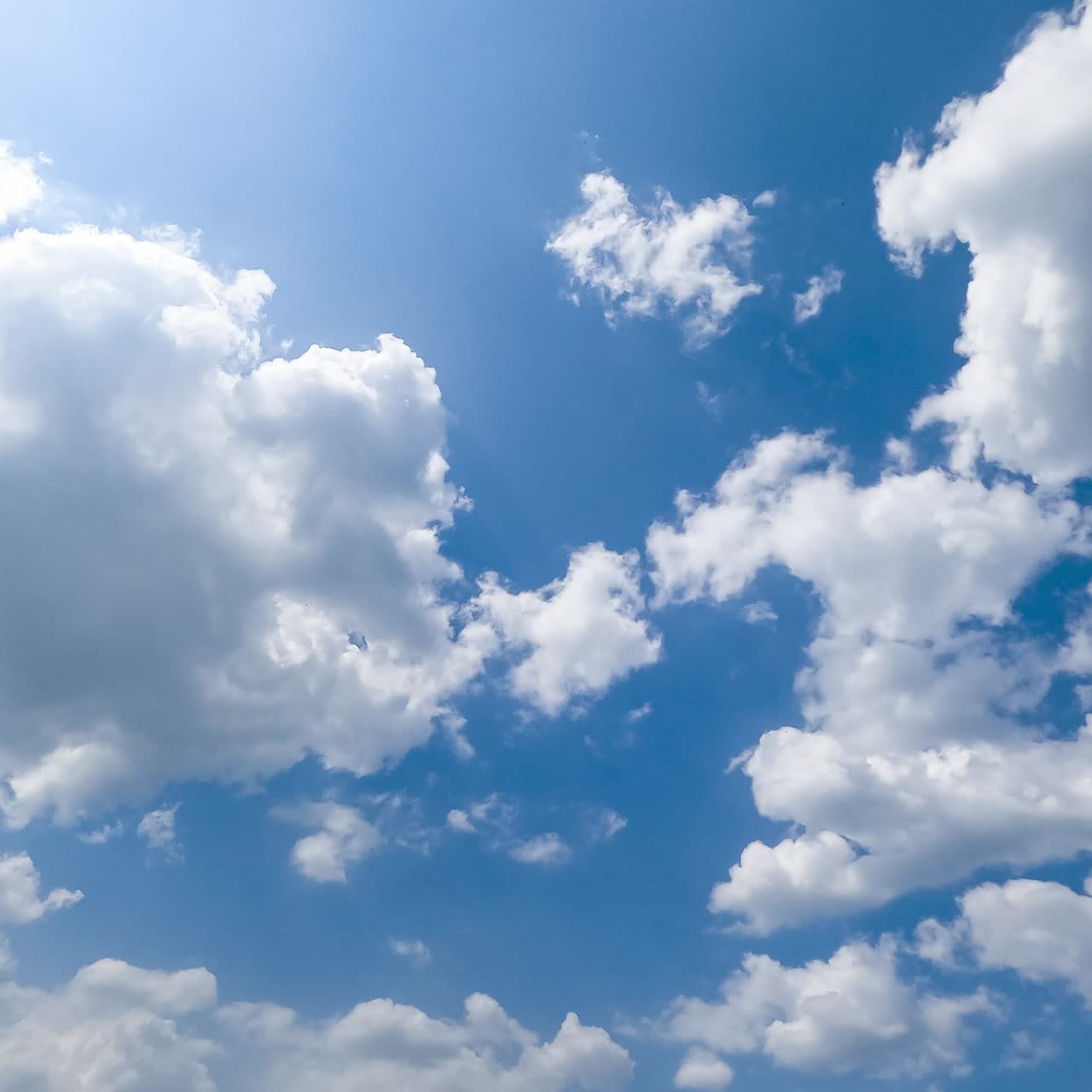 Building cloudscape on beautiful bright summer day. Light cotton clouds in the beams of sun timelapse