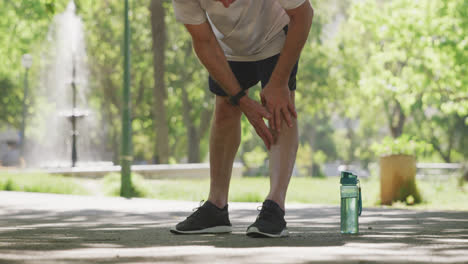 Hombre-Mayor-Con-Dolor-Sosteniendo-Su-Pierna-En-El-Parque