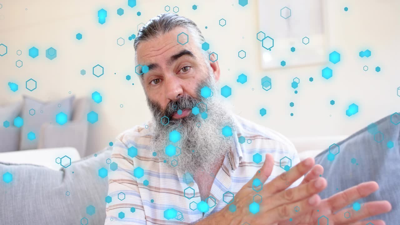 Man starting marketing talk on couch, framing widening and gesturing while blue hexagons drifting