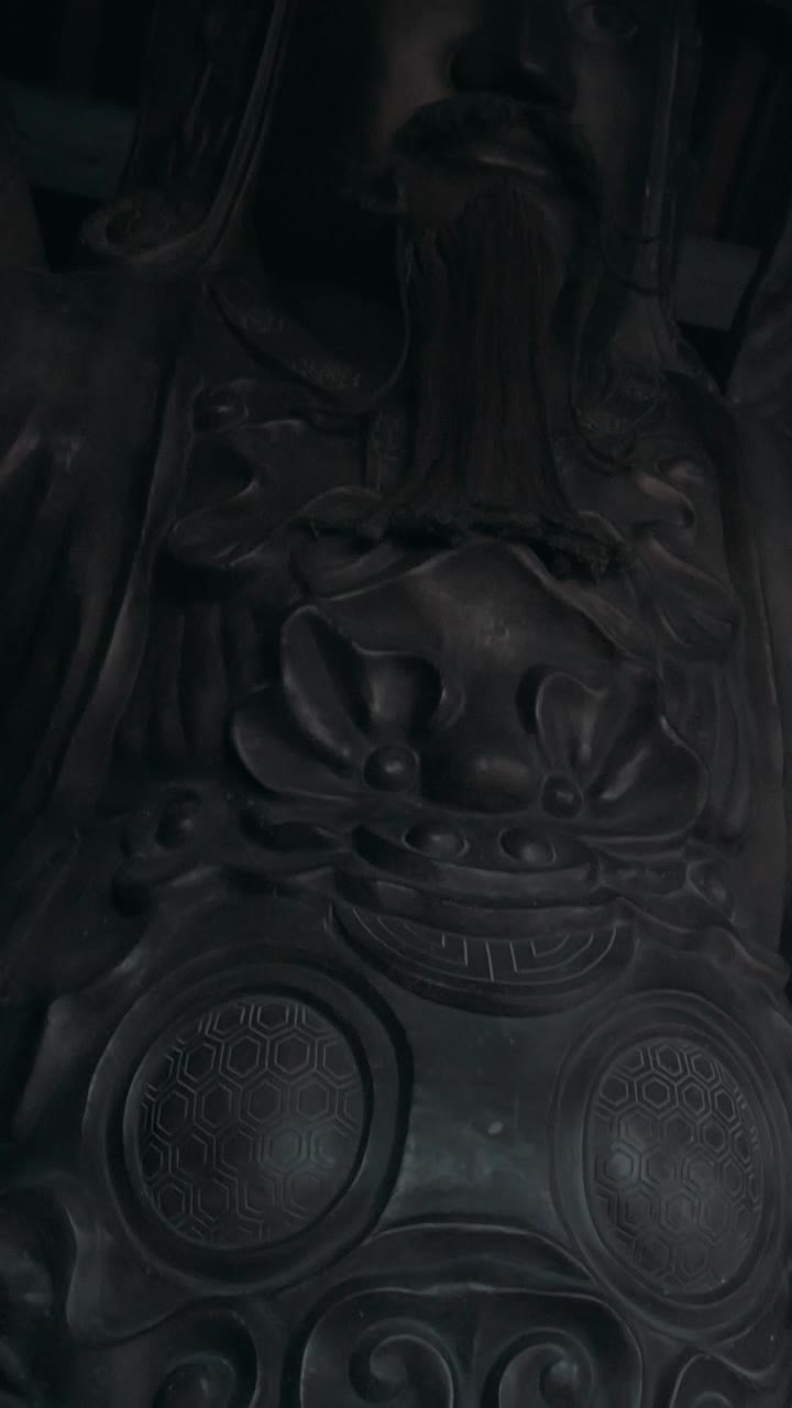 Statua scura e ornata di un'antica divinità guerriera asiatica