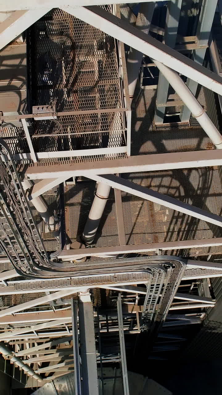 Modern metal grain elevator on field. Granary for storing and processing agricultural crop. Aerial view. Vertical video