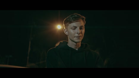 young man in hoodie at night
