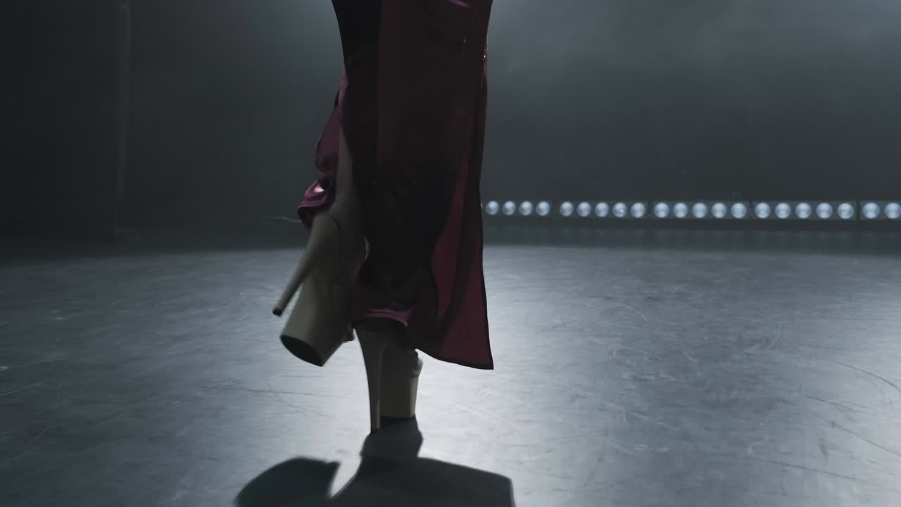 joven bailarina de tacones entrando en el escenario. primer plano de las piernas de la mujer. escenario ahumado