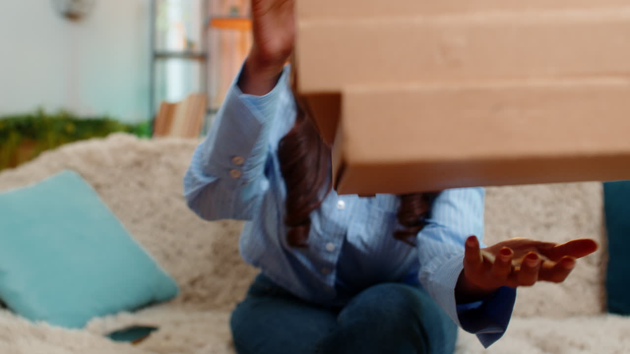 Indian woman ordering fast food online on smartphone and smiling while waiting for delivery at home
