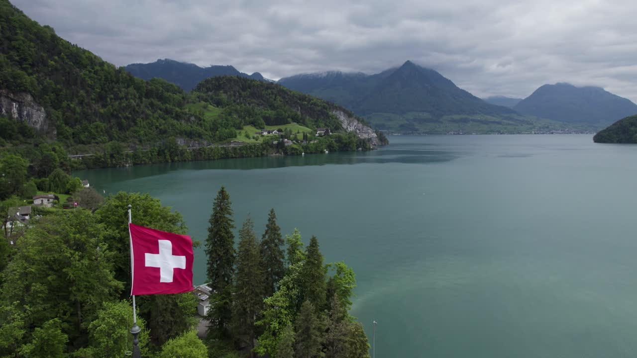 швейцарский флаг машет с великолепным горным ландшафтом озера люцерн
