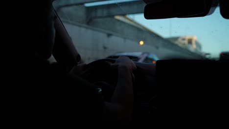 man driving car on highway at dusk
