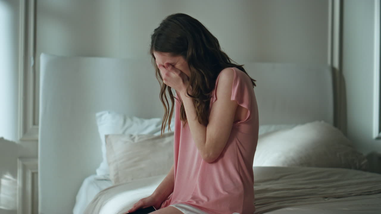 슬픈 소녀는 밤에 침대에서 울고, 실망하고, 잠을 못 자고, 슬퍼하고, 고통받고 있습니다.