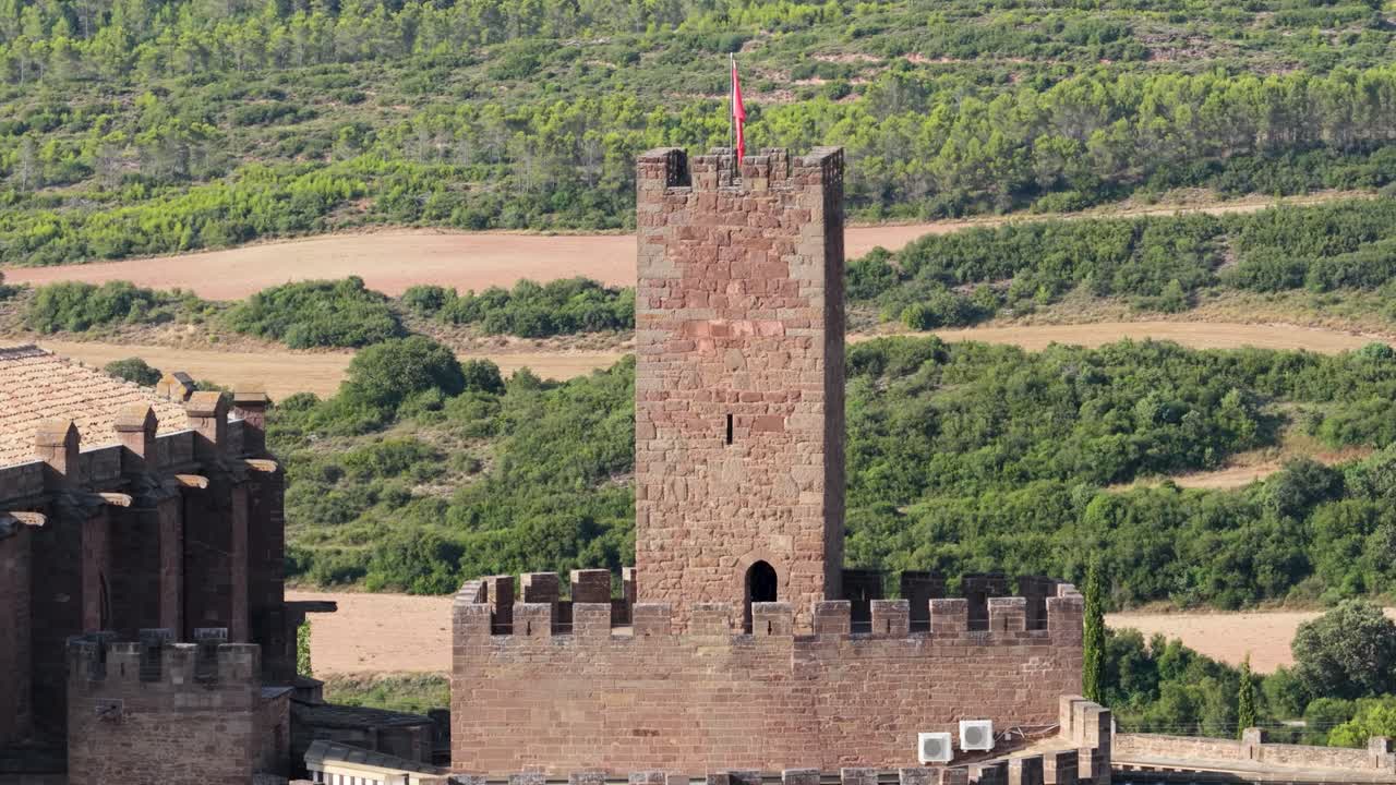 Torre di un castello medievale con una bandiera rossa in cima